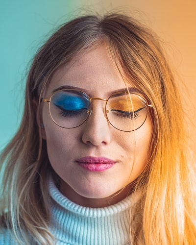 穿白色高领毛衣戴蓝色太阳镜的女人